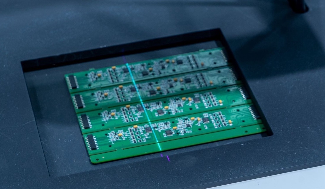A panel of real circuit boards being checked on an inspection machine